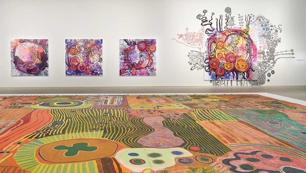 Foreground: Ngurrara Artists, Ngurrara Canvas II, 1997. Courtesy of the artists and the Ngurrara Canvas Management Group (NCMG) © Ngurrara Artists. Background: Yaritji Young, Tjala Tjukurpa III, 2025; Tjala Tjukurpa II, 2025; Tjala Tjukurpa IV, 2025; Tjala Tjukurpa I, 2025; Tjala Tjukurpa, 2026., 2026. Courtesy of the artist and Tjala Arts © Yaritji Young. Installation view, 25th Biennale of Sydney, Rememory, 2026, Art Gallery of New South Wales. Photo © Art Gallery of New South Wales, Felicity Jenkins.