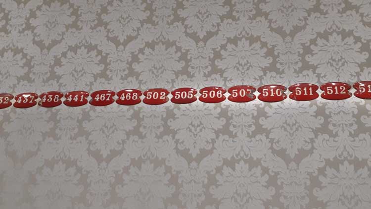Red room number plates from the abandoned hotel. Photo: Ana Duarte.