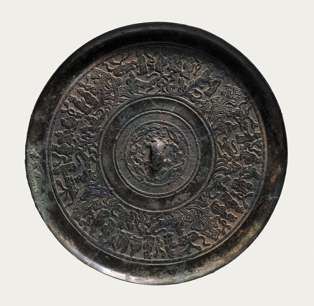 Bronze mirror with portrayals of people, Western Han (206 BCE – 8 CE), Diameter 18.6 cm (7 3/8 in), T (at edge) 0.9 cm (3/8 in), excavated in 1994 from the Marquis of Wanqu’s tomb at Bojishan. Collection of the Xuzhou Museum. 人物画像铜镜,西汉,直径18.6、缘厚0.9厘米,1994年簸箕山宛朐侯墓出土,徐州博物馆藏