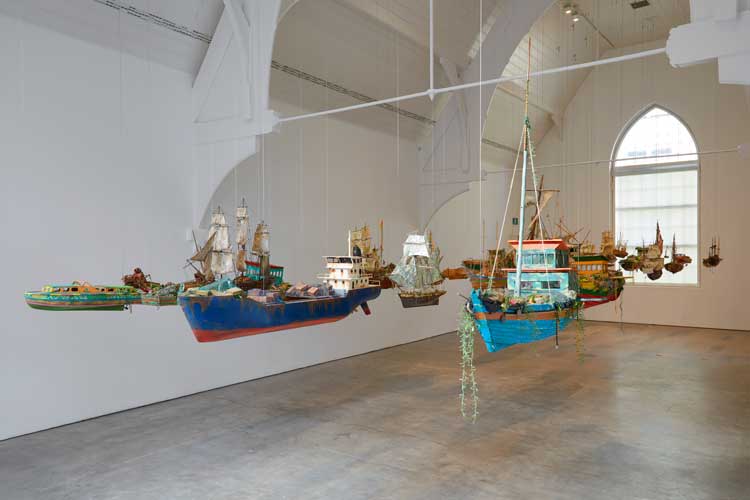 Hew Locke, Armada, 2017-19. Installation view, Here’s the Thing exhibition, Ikon Gallery, Birmingham, 2019. Courtesy the artist and Ikon Gallery. Photo: Stuart Whipps.