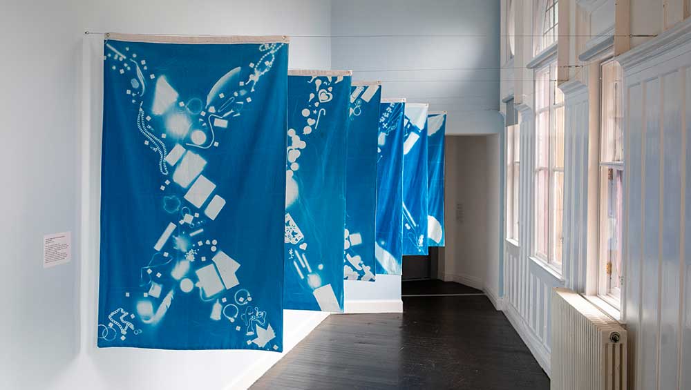 Alixandra Prybyla, with workshop participants, Saltire Series, 2026. Cyanotype on cotton. Installation view, We Make Museums, Glasgow Women's Library, 2026. Photo: Matthew Arthur Williams.