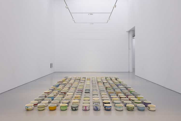 Sophia Al-Maria and Lydia Ourahmane. Job Lot, late 1700s-2024. An inheritance of 240 porcelain chamber pots, acrylic newspaper clip, frame. Installation view, Grey Unpleasant Land at Spike Island, Bristol, 2024. Photo: Rob Harris.
