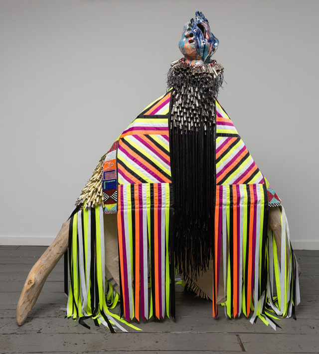 Jeffrey Gibson. ALL FOR ONE, ONE FOR ALL, 2015. Driftwood, hardware, wool, canvas, glass beads, artificial sinew, metal jingles, nylon fringe, ribbon, steel studs, high fire glazed ceramics, 60 x 72 x 74 in. Image courtesy of Jeffrey Gibson Studio. Photograph: Peter Mauney.