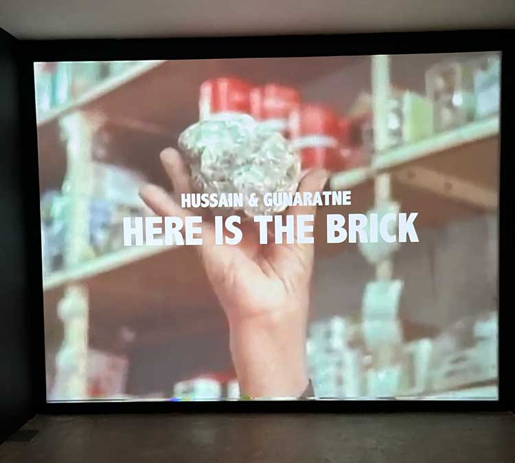 Here is the Brick, 2025. Video, colour, sound, 13:39 mins. Mahtab Hussain with Guy Gunaratne. Installation view, Mahtab Hussain, What Did You Want To See? Ikon Gallery, 2025. Image courtesy Ikon. Photo: David Rowan.