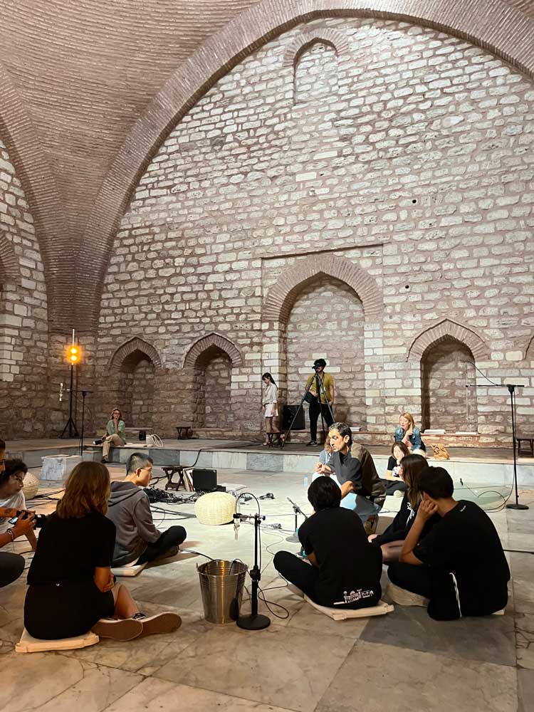 Tarek Atoui (centre) leads a Whispering Playground workshop in Küçük Mustafa Paşa Hammam. Photo: Veronica Simpson.