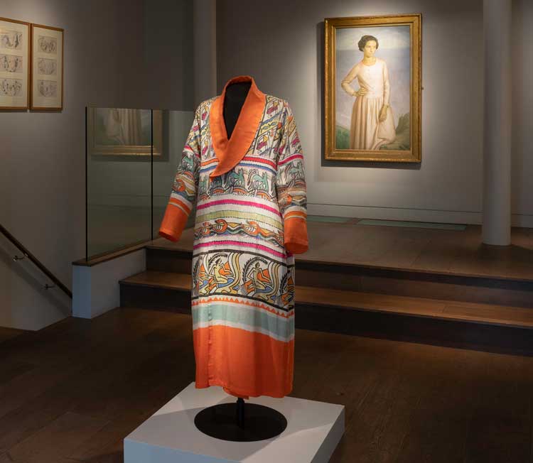 Percy Wyndham Lewis, Robe, 1913-14. Embroidered and block-printed silk robe. Background: Henry Lamb, Edie McNeill, 1911. Oil on canvas. On loan courtesy of Southampton City Art Gallery. Copyright The Artist. Reproduced by kind permission of the Henry Lamb Estate. Installation view, Augustus John and the First Crisis of Brilliance, Piano Nobile, London 2024. Photo courtesy of Piano Nobile, London.