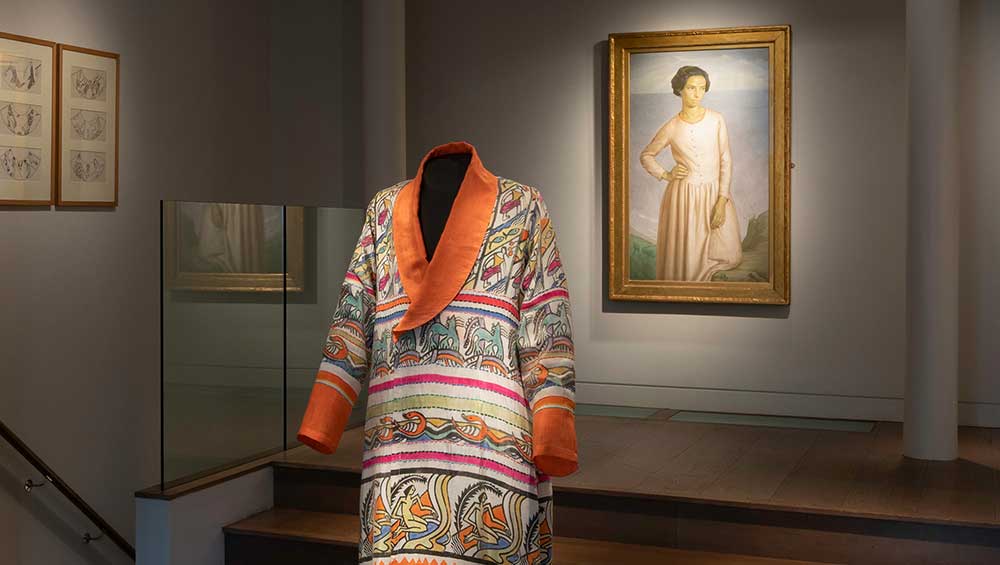 Percy Wyndham Lewis, Robe, 1913-14. Embroidered and block-printed silk robe. Background: Henry Lamb, Edie McNeill, 1911. Oil on canvas. On loan courtesy of Southampton City Art Gallery. Copyright The Artist. Reproduced by kind permission of the Henry Lamb Estate. Installation view, Augustus John and the First Crisis of Brilliance, Piano Nobile, London 2024. Photo courtesy of Piano Nobile, London.