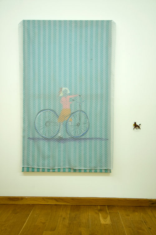 Jenny Watson. Bicycle girl 2007. Acrylic on rabbit skin glue primed cotton, stretched, with flecked voile overlay + s
mall plastic horse, 152 cm x 89 cm. Courtesy Transit Gallery, Mechelen, Belgium.