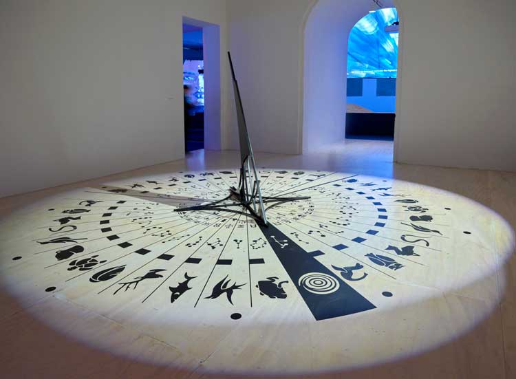 Ayoung Kim. Delivery Dancer’s Arc: Inverse (detail). 2024. Three-channel video, lighting installation, random video playback and lighting synchronization control program, sundial sculpture, graphic sheets, and circular screen. Courtesy MoMA PS1. Photo: Roz Akin.