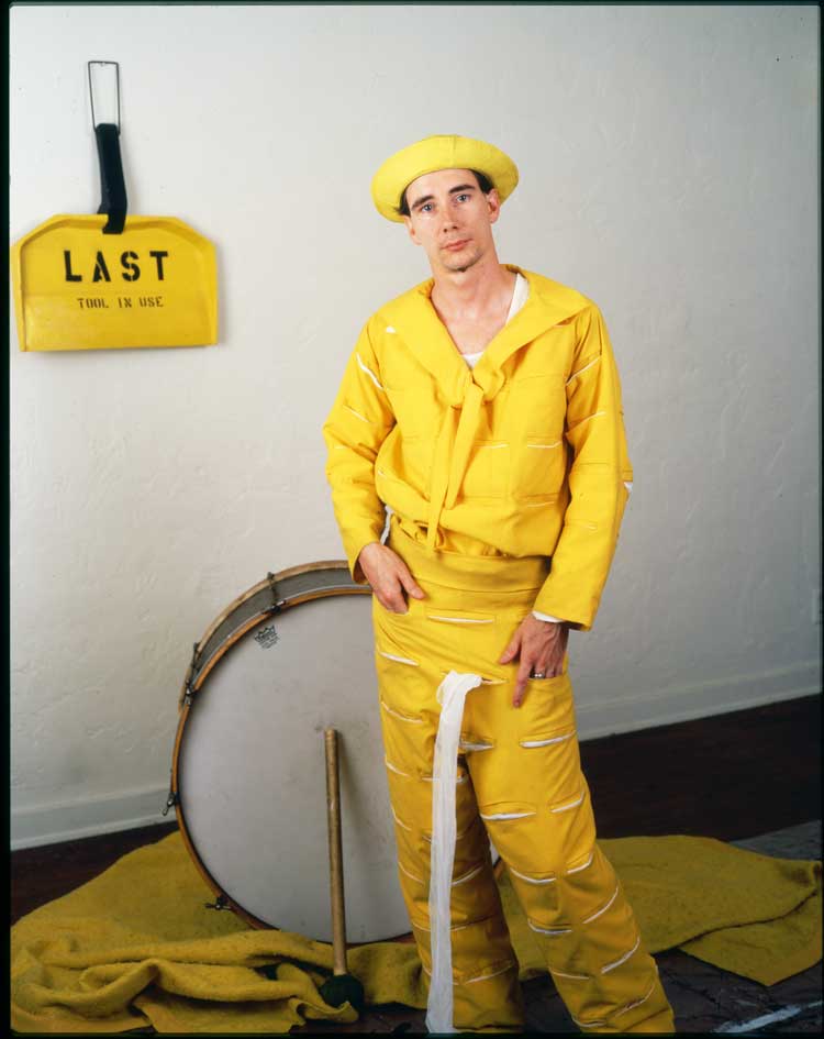 Jim McHugh portrait of Mike Kelley as The Banana Man, c1983, with (in the background) Last Tool in Use, 1977. Enamel 73.7 × 55.3 × 7.6. Photo © Jim McHugh.