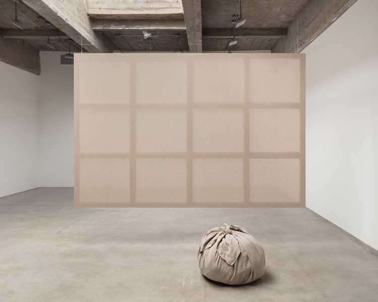 Kimsooja, Meta-Painting, 2024. Linen canvas stretched on wooden frame, bottari made of linen canvas and used linen clothes, 200 x 300 x 3 cm (painting), 50.8 x 71.1 x 68.6 cm (bottari). Courtesy the artist and Tanya Bonakdar Gallery, New York / Los Angeles.
