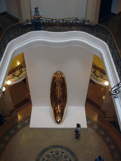 A visitor in the foyer of the CCBB Sao Paulo observes Anish Kapoor's Untitled at 'Ascension'. Untitled, 1999, brass, 445 x 124 x 108 cm