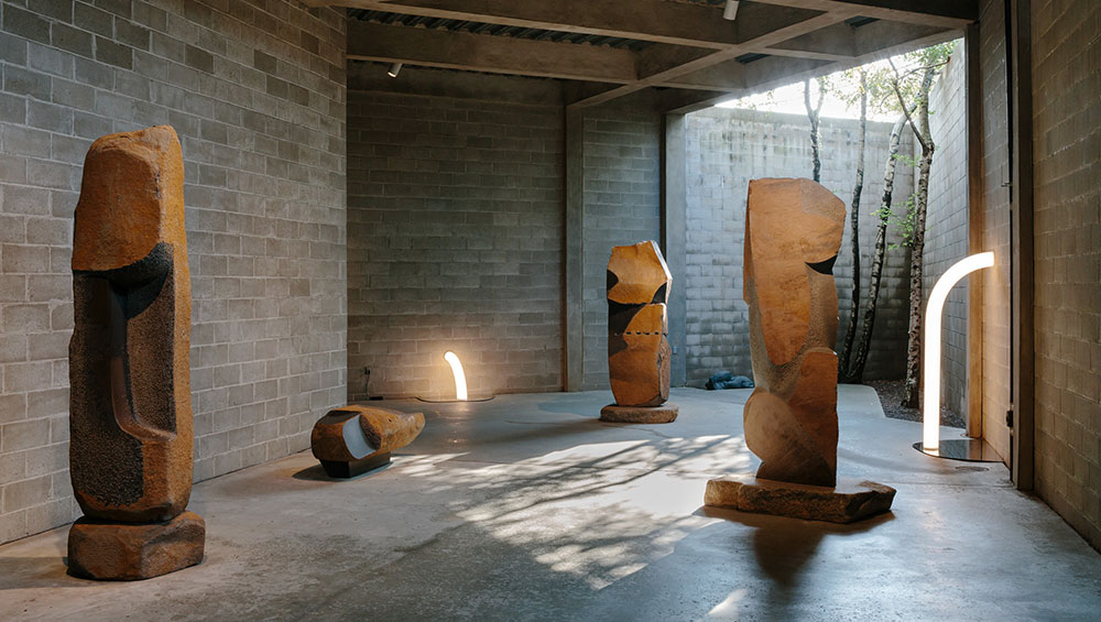 Objects of Common Interest, Tube Light I and Tube Light II, 2019, installed among Isamu Noguchi’s late-career basalt and Manazuru stone sculptures in The Noguchi Museum’s indoor-outdoor gallery, Area 1. Photo: Brian W. Ferry. ©INFGM / ARS.