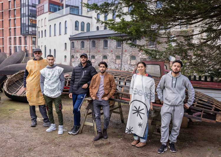 Ceyda Oskay (second from right) with musicians (from left): Rory, Hasibullah, Fouad, Hashmat and Ayman, at Meitheal Mara Teoranta boatbuilding yard in Cork. Photo courtesy John Beasley, Cork, 2022.