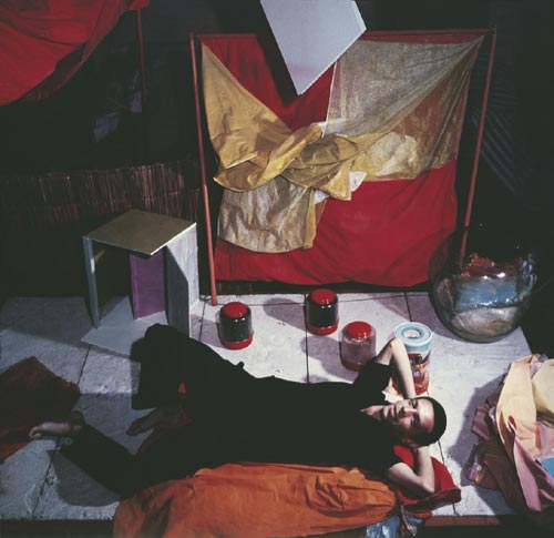Hélio Oiticica with Bólides and Parangolés at his atelier at Engenheiro Alfredo Duarte Street, Rio de Janeiro, c.1965 AHO/ PHO, RJ. (c) Projeto Hélio Oiticica