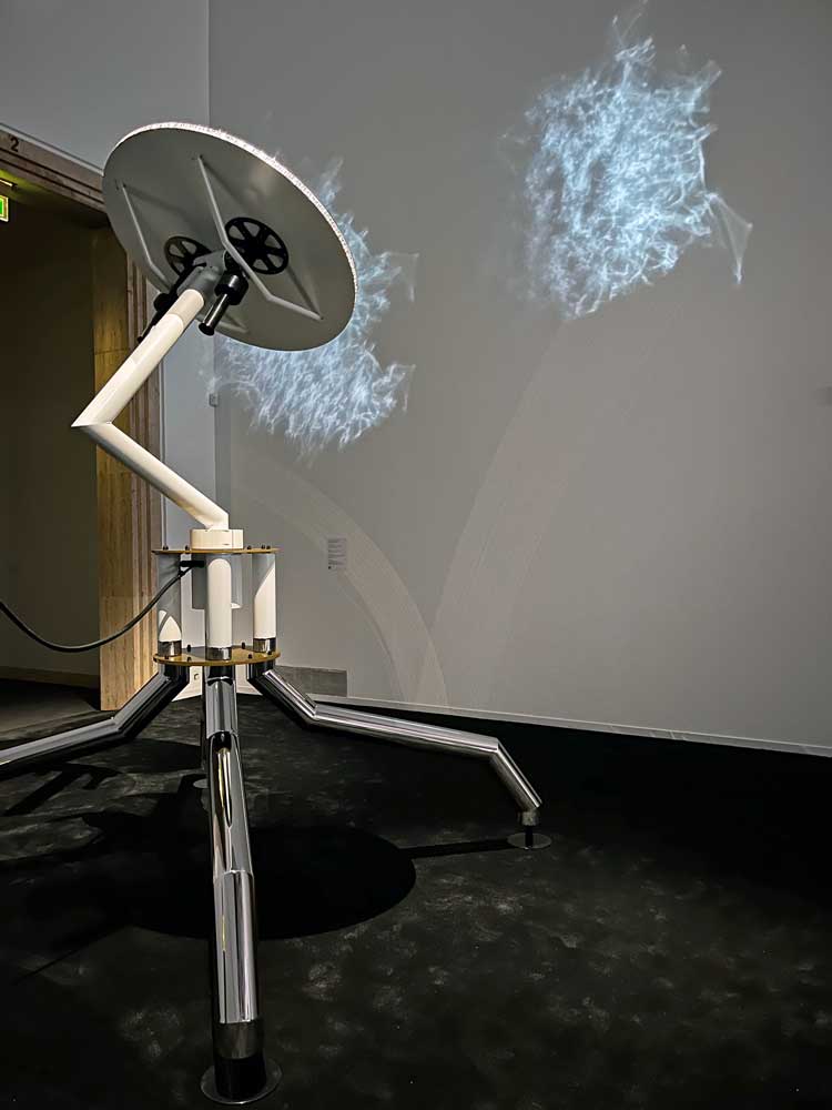 Robotic figure casting silvery webs around the main gallery. Installation view, Philippe Parreno: Voices, Haus der Kunst, Munich, 13 December 2024 – 25 May 2025. Photo: Veronica Simpson.