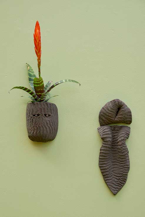 Lucia Pizzani, Seres Tropicales, 2024. Mural installation, 10 black stoneware clay sculptures imprinted with corn, live plants. Photo: Andy Keate, courtesy of Cecilia Brunson Projects.