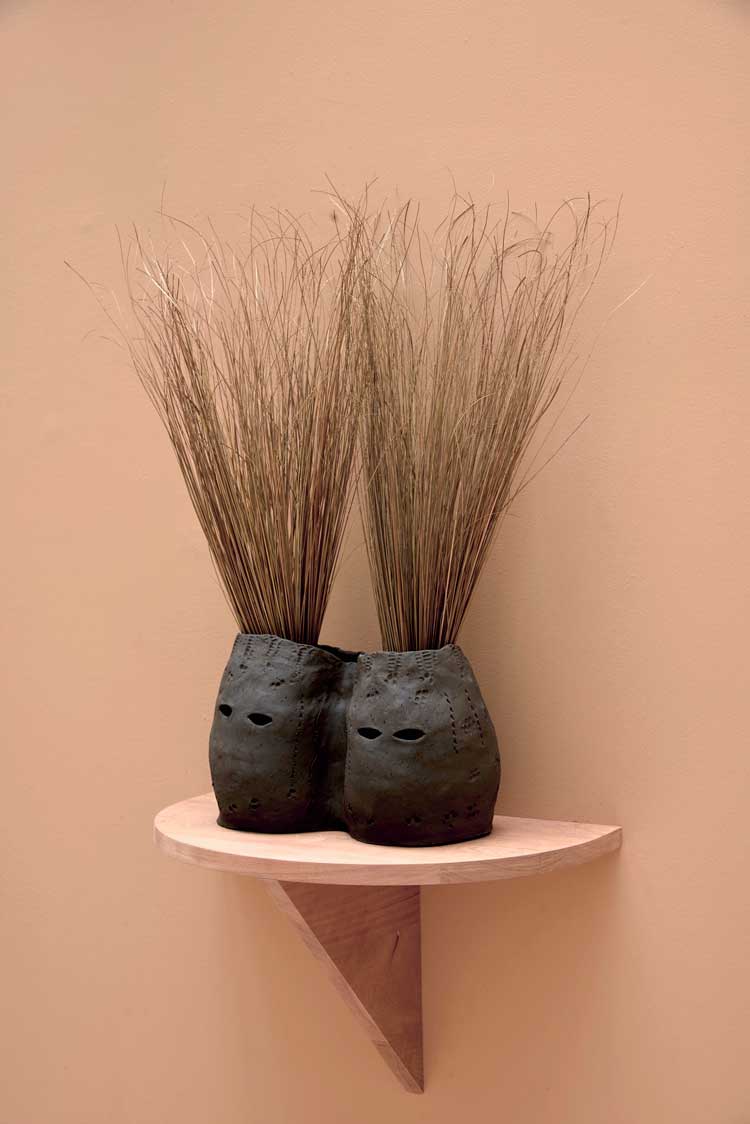 Lucia Pizzani, Siamesas, 2024. Black stoneware and dry palm fibre, 36 x 22 x 76 cm (14 1/8 x 8 5/8 x 29 7/8 in). Photo: Andy Keate, courtesy of Cecilia Brunson Projects.