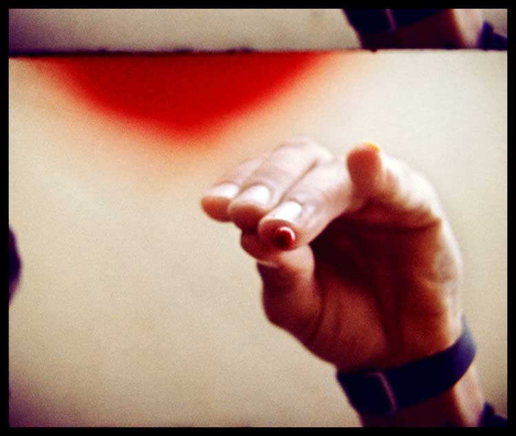Mike Parr. Drip blood from your finger onto the lens of a camera, until the lens is filled with blood. Performed at Woolloomooloo, Sydney 1972. 16mm film still.