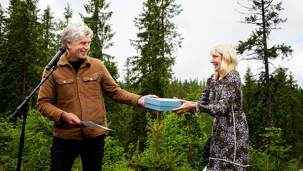 Future Library. Karl Ove Knausgård hands his manuscript to Katie Paterson, Nordmarka forest, Oslo, Norway. Photo: Kristin von Hirsch.