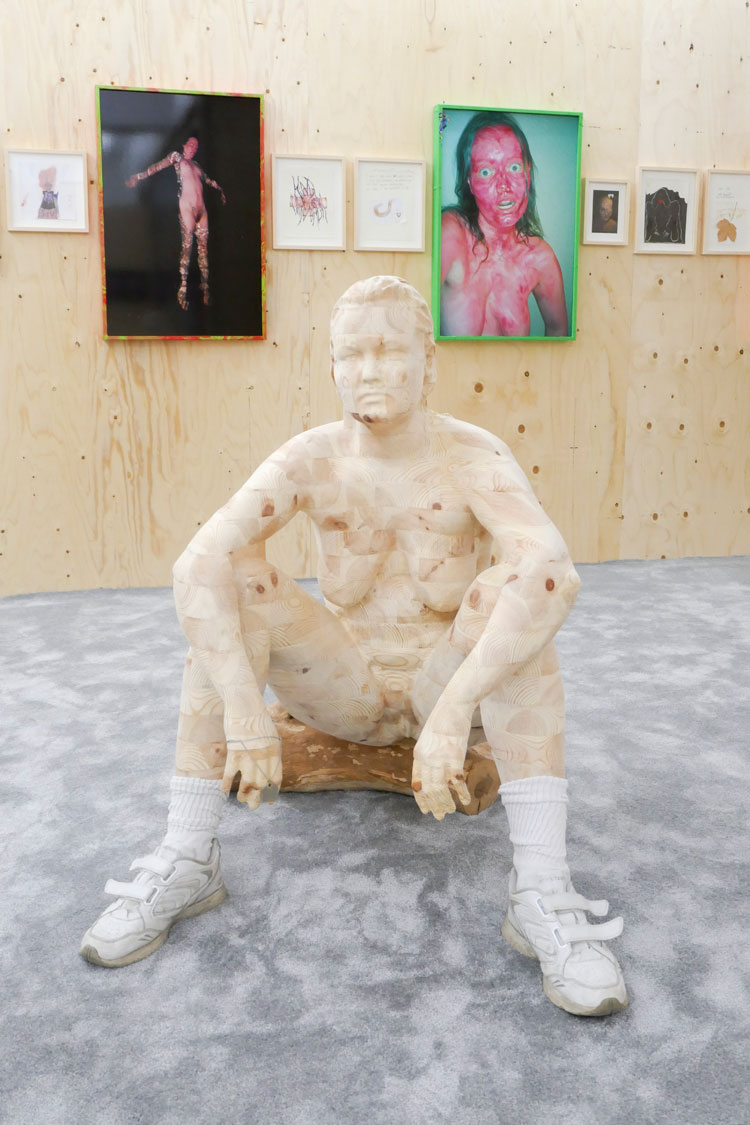 Maria Pasenau. Self-portrait With Graveyard Log, 1994-2019. Carved wood sculpture in pine, shoes and socks from the United States, and stump from Our Saviour cemetery. © the artist.