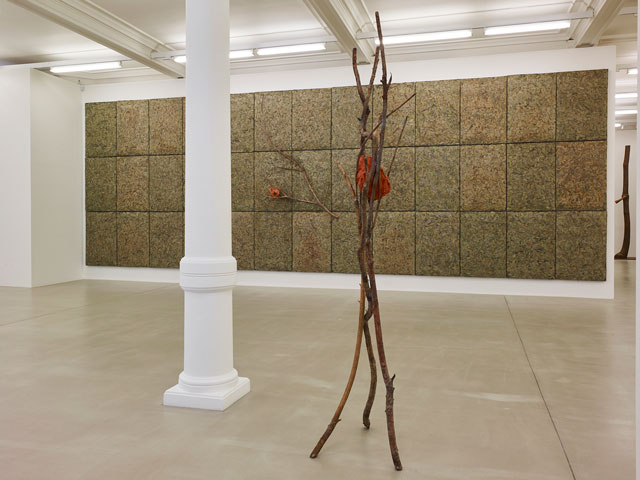 Foreground: Giuseppe Penone, Terra su terra – Volto, 2014. Bronze, terracotta, 240 x 100 x 60 cm. Background: Giuseppe Penone, Respirare l’ombra, 2008. Metallic wire, laurel leaves, bronze, variable elements, dimensions variable. Courtesy of Marian Goodman Gallery.