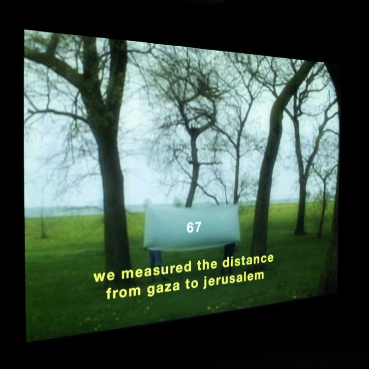 Basma Al Sharif, We Began By Measuring Distance (still), 2009. Commissioned by Sharjah Art Foundation and produced by Sharjah Art Foundation and Ramattan News Agency & Media Services. Installation view, In the eyes of our present, we hear Palestine, Old Al Dhaid Clinic, Sharjah, 2023–24. Photo: Danko Stjepanovic.