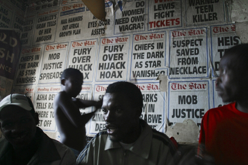 Guy Tillim. Ntokozo and his brother Vusi Tshabalala at Ntokozo's place, Milton Court, Pritchard Street, Johannesburg, 2004. Pigment print on cotton paper, 19 3/4 x 28 1/8 in © Guy Tillim. International Center of Photography.