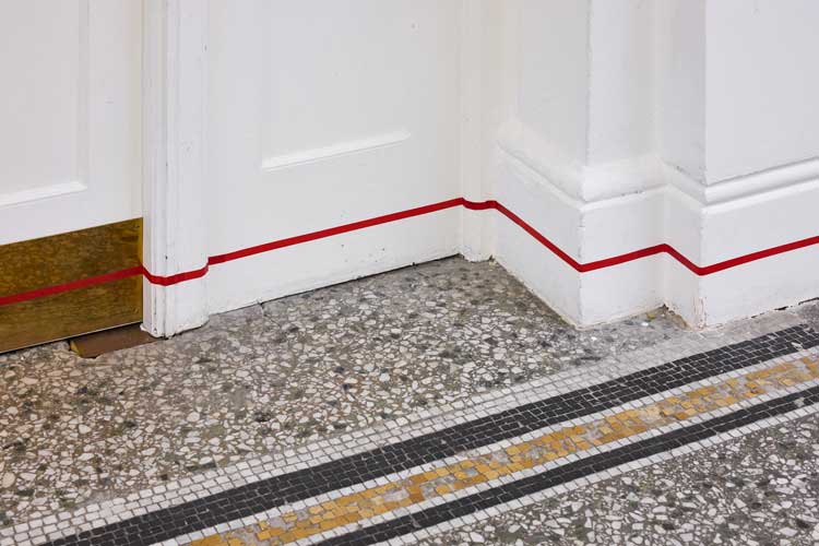 Continuous Red Line, 2002 - ongoing. Red splicing tape, dimensions variable. Installation view, There: a Feeling | Gregg Bordowitz, Camden Art Centre, London 2025. Photo: Luke Walker.
