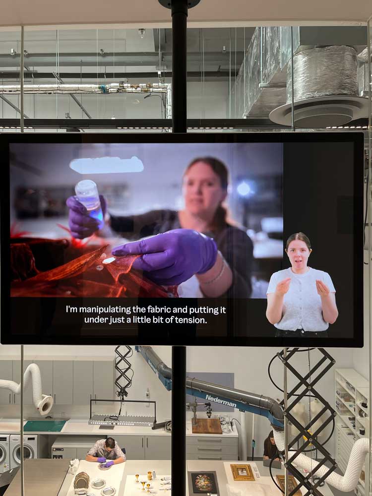 V&A East Storehouse. A film explains the work of the conservators visible in the laboratory the floor below. Photo: Veronica Simpson.