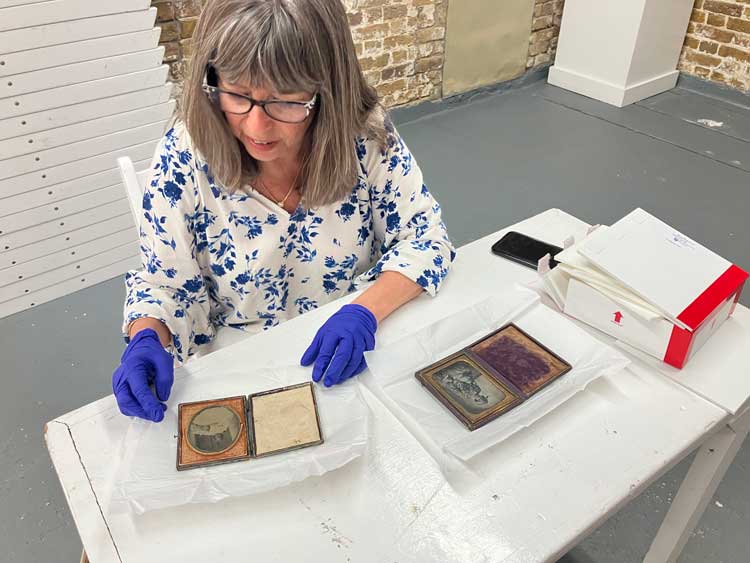 The artist Joscelyn Gardner examining the two ambrotype portraits of Harriet Thomas Weekes at the Barbados Museum & Historical Society, 2025. Photo: Natalie McGuire.