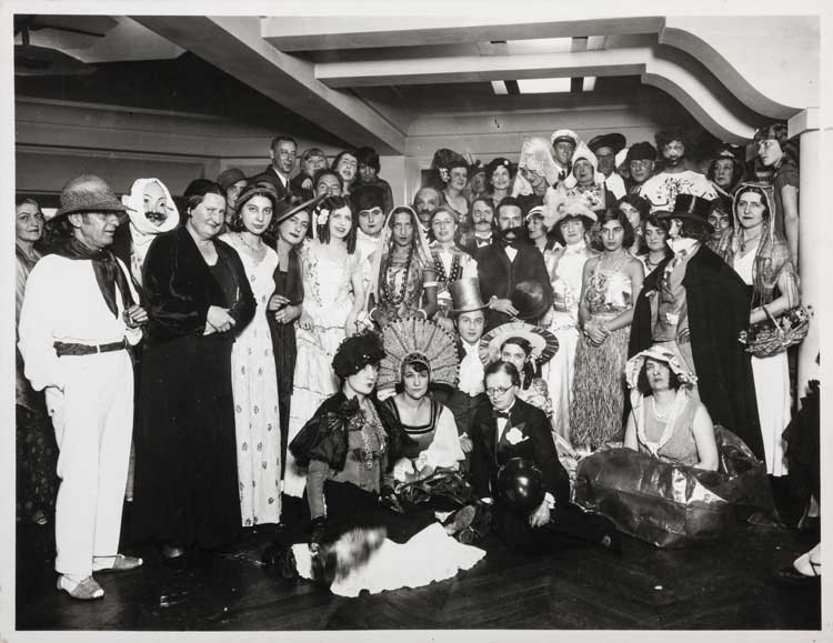 Marc Louis René Vaux. Masked Ball for the Thirtieth Anniversary of the B. Weill Gallery, December 13, 1931. (Berthe Weill seated in a tuxedo at the center). Photograph, 15.8 × 20.5 cm. Marianne Le Morvan Collection – Berthe Weill Archives (gift of Antoinette Karlinsky). © photo: Musée d’Orsay / Allison Bellido / © Centre Pompidou - MNAM / CCI - Bibliothèque Kandinsky.